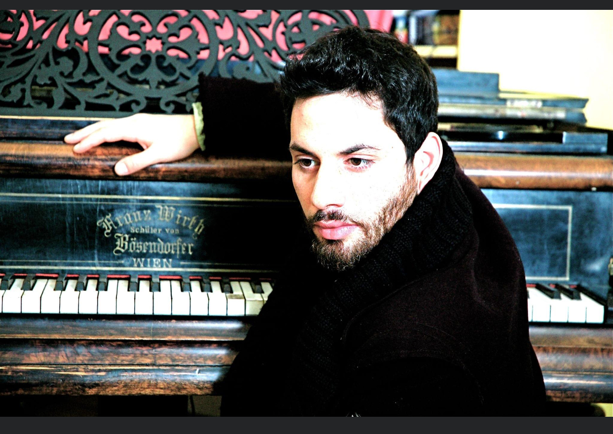 A younger Marek beside a vintage Bösendorfer piano