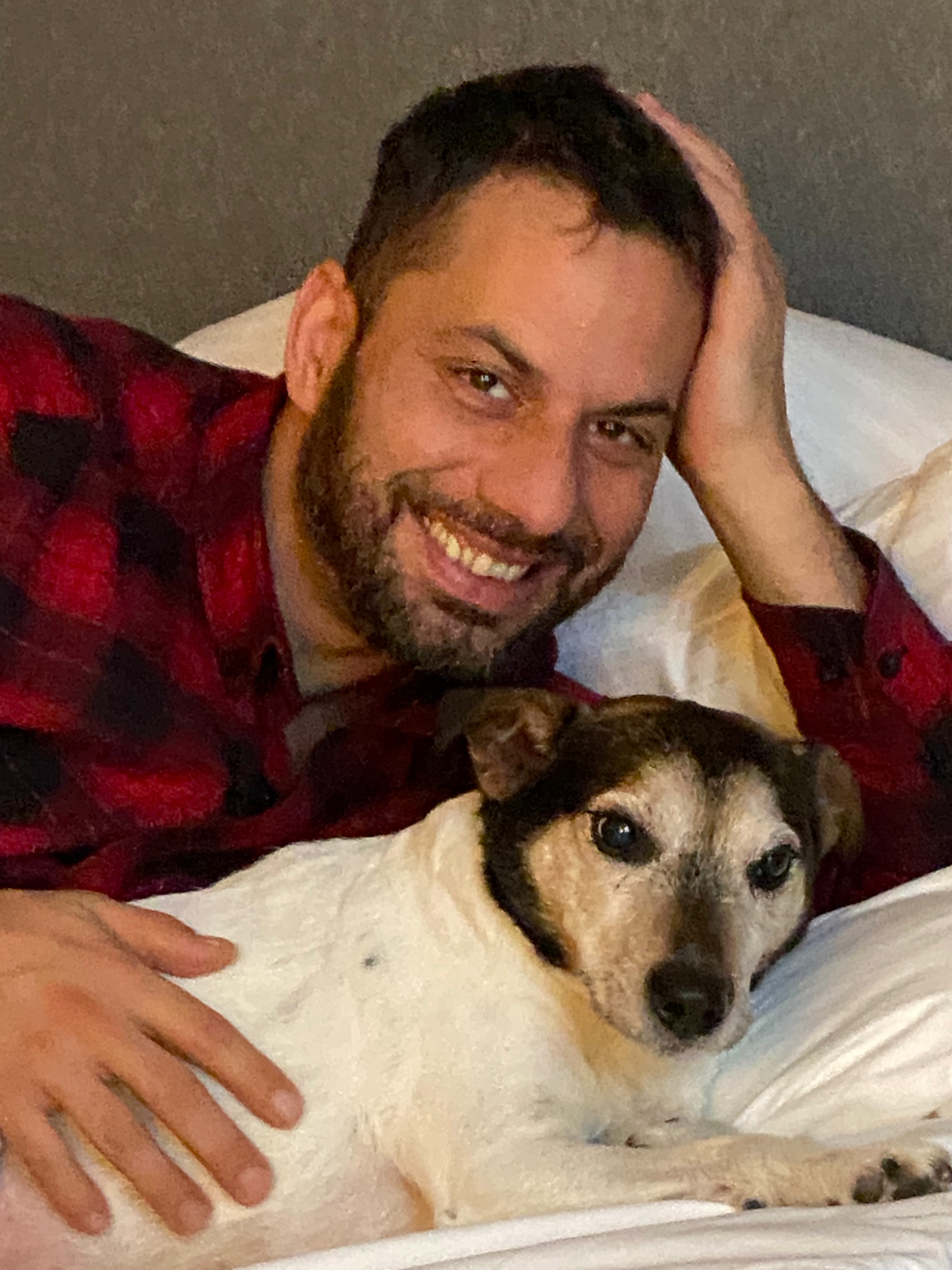 Marek smiling with his black-and-white dog