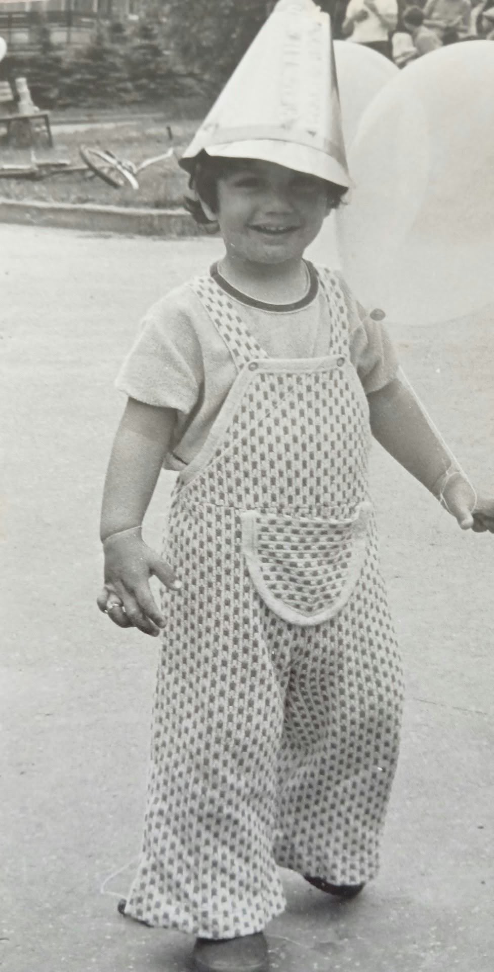 A childhood photograph of Marek wearing a paper hat